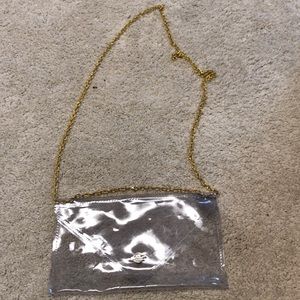 Clear clutch with gold strap. Never used.